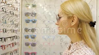 年轻女子正在<strong>眼镜店</strong>里挑选太阳眼镜